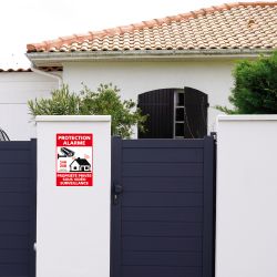 Pancarte de sécurité protection alarme apposée sur un muret d’une propriété privée